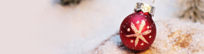 Rote Weihnachtskugel mit Schneeflocke auf Schneebedecktem Tisch