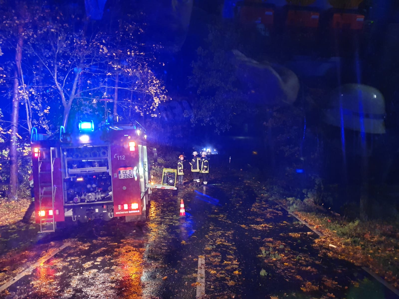 Feuerwehrauto auf regennasser Fahrbahn mit Blaulicht