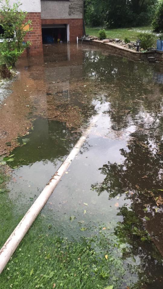 Unter Wasser stehende Garage mit Feuerwehrschlauch